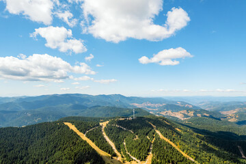 Panorama of beautiful nature aerial view white clouds, blue sky, horizon, mountains, pine forest and meadows. Nature. Relax