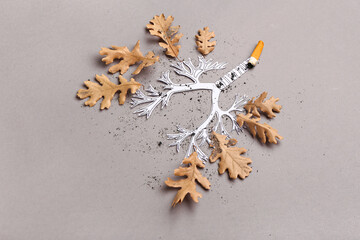 Lungs made of paper, cigarette butt and dry oak leaves on grey background