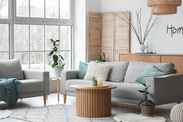 Interior of stylish living room with sofas and willow branches in vase