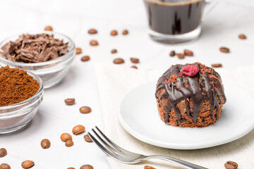 Round chocolate cakes. Decorated with candied raspberries. Light background.