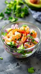 Closeup of shrimp avocado salad with red onions, cilantro, and tomatoes in a glass bowl. Healthy and fresh seafood dish with vibrant colors