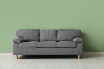 Cozy sofa near green wall in stylish living room
