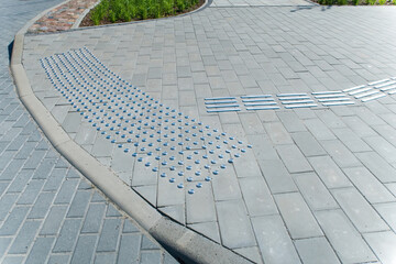 Sidewalk for the visually impaired. Metal blocks of tactile covering for blind people with...