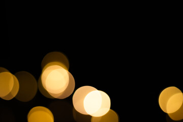 Blurred yellow christmas lights on black background. Yellow light bulbs.