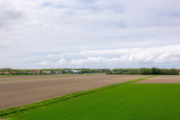 Spring landscape, Typical Dutch polder land with blue sky and white could, Plowed the soil on the filed for agriculture and green grass filed, Countryside of Texel Island, Noord Holland, Netherlands.