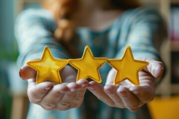 A person holds three bright yellow stars in their hands, symbolizing achievement or celebration