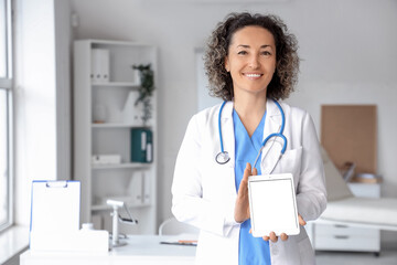 Mature female doctor with tablet computer in clinic