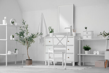 Interior of stylish modern bathroom with commode and decorative olive tree