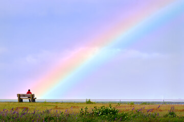 Fototapeta premium Salish Sea Rainbow. Clouds and a rainbow over the Garry Point marshes on the edge of the Salish Sea. Richmond, British Columbia, Canada near Vancouver.