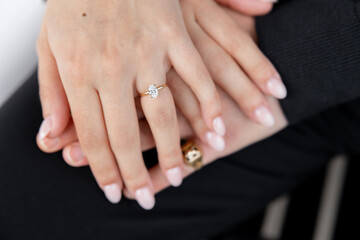 Close-up of a man's and woman's hand with a ring on the finger and a gemstone. Couple in love, man and woman holding hands. Beautiful engagement ring with a large gemstone