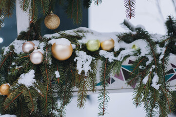 Shiny mirror balls decorate spruce branches with snow. Christmas decorations and toys. Winter...