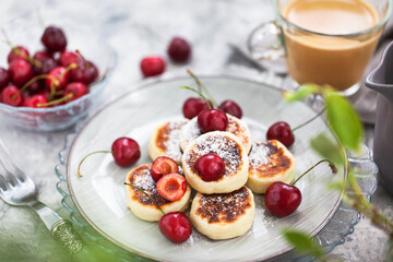 Cottage cheese pancakes with fresh cherry and coffee for breakfast