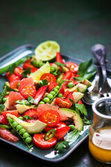 Spring salad witn avocado, tomato, strawberry, grapefruit, green pea and herbs