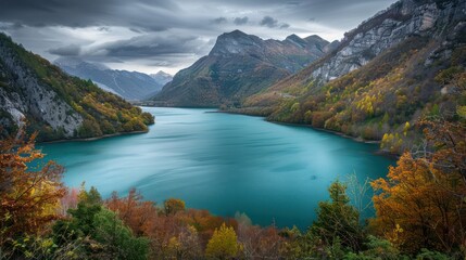 A breathtaking landscape showing a serene lake with surrounding autumn-colored foliage and towering mountains under a dramatic sky