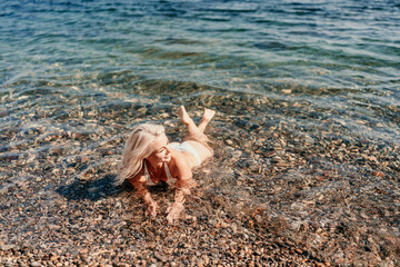 A woman is laying in the water at the beach