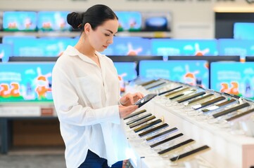 Portrait of happy young woman buying a new smartphone in store. Shopping a new digital device
