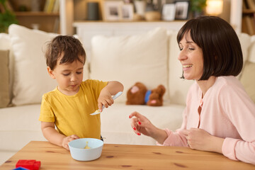 Little boy having healthy meal in the living room