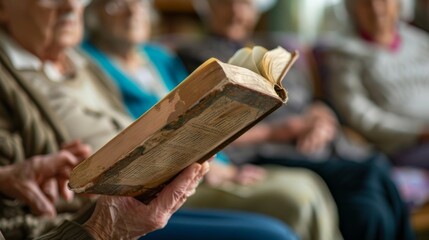 A volunteer reading a book out loud to a group of elderly residents at an assisted living facility