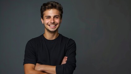 Obraz premium A young handsome man smiling with his arms crossed isolated on a grey background.