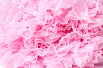 delicate thin pink fabric with many ruffles close-up.