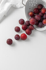 Top View of Red Plums on a White Countertop