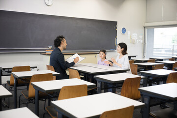 面談を受ける親と子供　小学校の教室での三者面談のイメージ