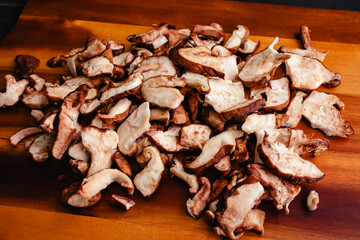 Sliced and Torn Shiitake Mushrooms Close-up on a Cutting Board: Fresh shitake mushrooms torn into bite-size pieces piled up on a wooden background