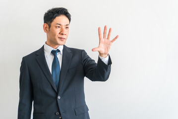 手のひらを拡げるスーツ姿の中年アジア人ビジネスマン
