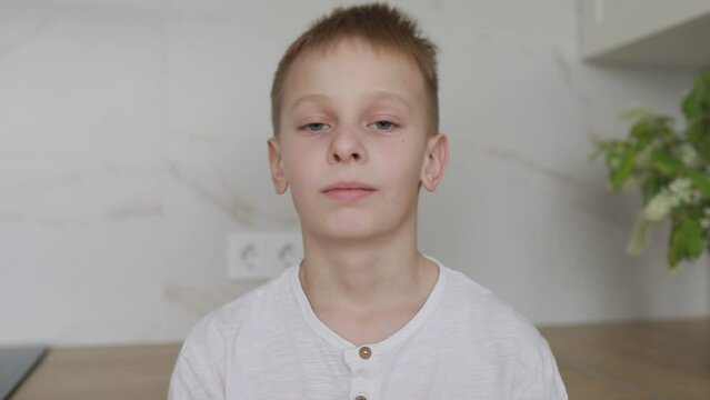 Young Boy Standing Still In A Brightly Lit Indoor Room During Daytime