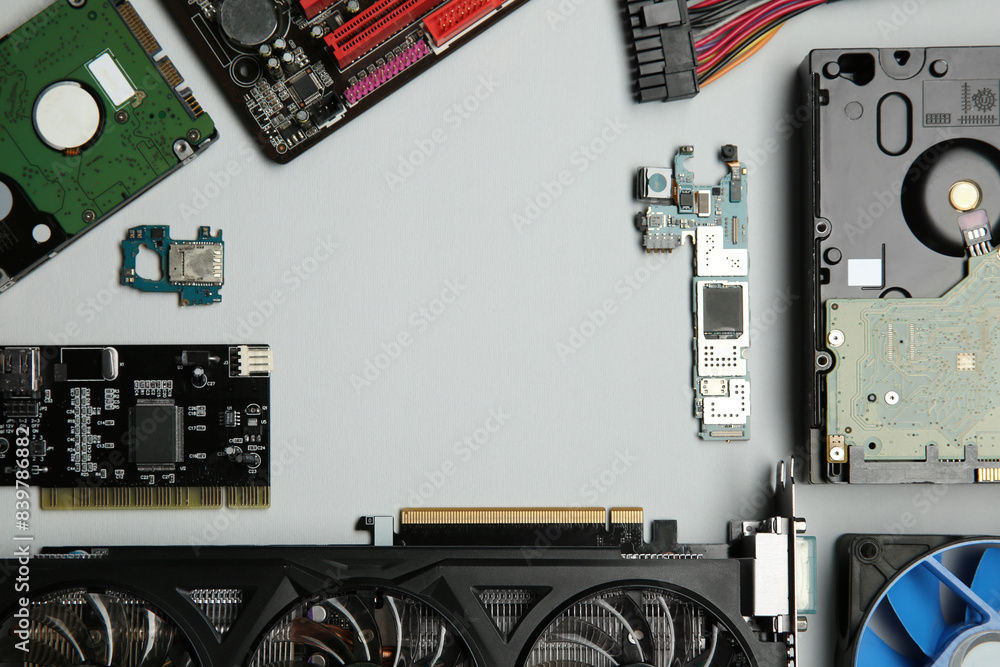 Poster frame of graphics card and other computer hardware on light background, flat lay. space for text