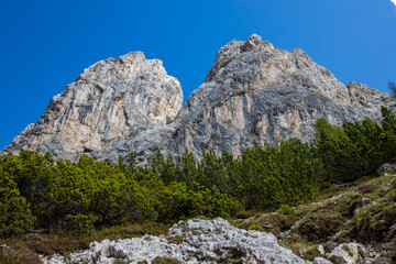 Dolomites mountains, Alpi Dolomiti beautiful scenic landscape in summer. Italian Alps mountain summits and rocky peaks above green valley alpine scene