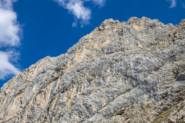 Dolomites mountains, Alpi Dolomiti beautiful scenic landscape in summer. Italian Alps mountain summits and rocky peaks above green valley alpine scene