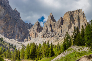 Obraz premium Dolomites mountains, Alpi Dolomiti beautiful scenic landscape in summer. Italian Alps mountain summits and rocky peaks above green valley alpine scene