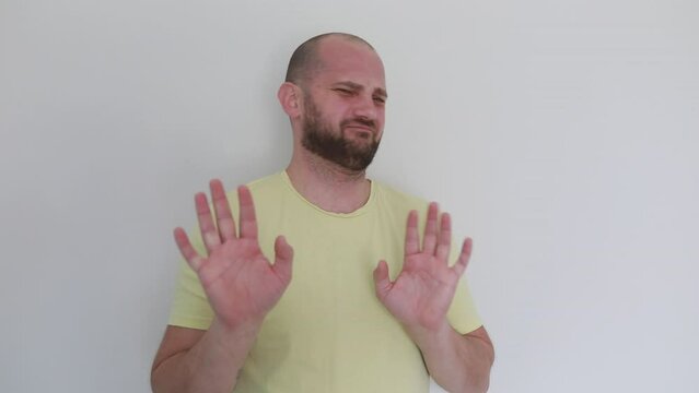 Man in Yellow Shirt Expressing Disapproval With Gestures Indoors