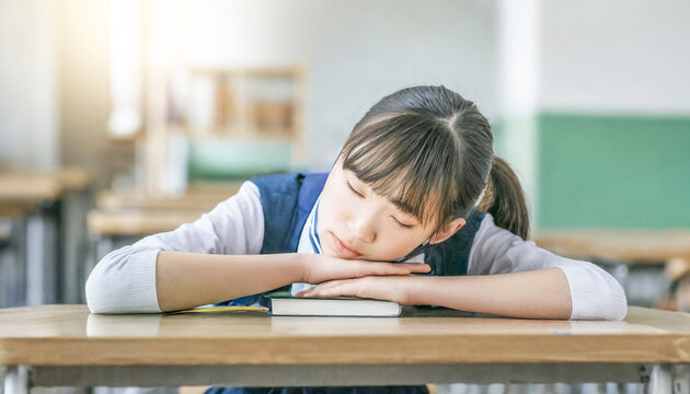 Oriental girls in school uniform dozing off in the classroom.