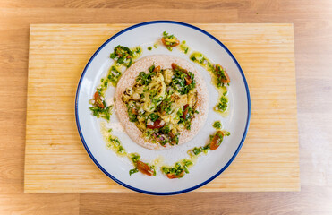 Tasty bean porridge with cauliflower and vegetables on white plate