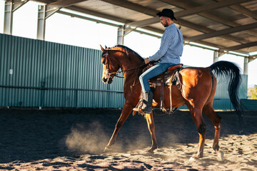 Man riding a horse in an equestrian center