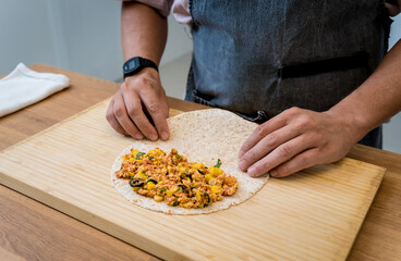 Chef at the kitchen preparing quesadillas with tofu and sweet corn