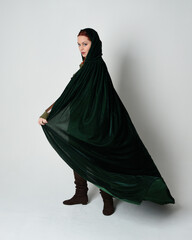 Full length portrait of red haired female model, wearing green medieval fantasy costume, long...