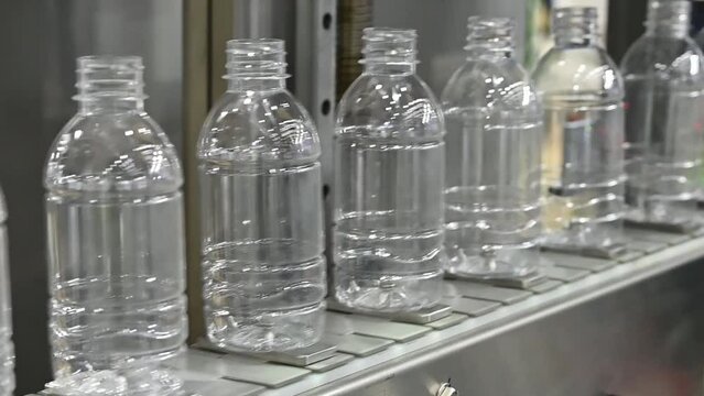 Slow motion scene the  empty drinking water bottles  on the conveyor belt for filling process.