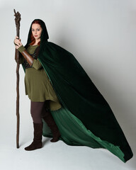 Full length portrait of red haired female model wearing green medieval fantasy costume leather...