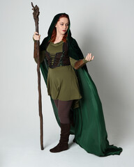Full length portrait of red haired female model wearing green medieval fantasy costume leather...