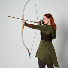 close up portrait of red haired female model wearing green medieval fantasy costume, leather...