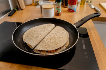 Chef at the kitchen preparing quesadillas with tofu and sweet corn