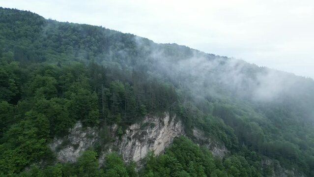 Clouds On Foggy Forested Mountain In Lepsa, Vrancea County, Romania. drone pullback shot
