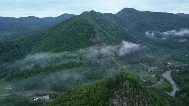 Thin Fog Clouds Over Forested Mountains Near Rural Village In Lepsa, Vrancea County, Romania. Aerial Shot