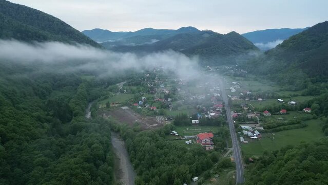 Fog Clouds Above Mountainous Village Of Lepsa In Vrancea County, Romania. aerial pullback shot