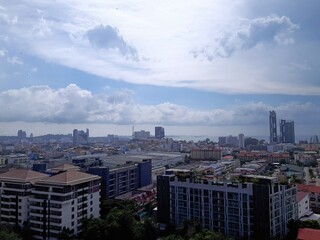Obraz premium Cityscape with ocean view under cloudy sky