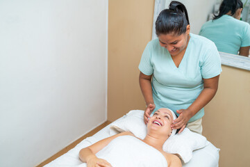 Friendly masseur giving a facial massage to a woman