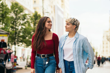 Fototapeta premium two teenager girls walking and talking in a city street
